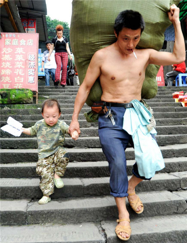 صورة الحمال الصيني ران جوانجي أثناء عمله و معه إبنه ذو الثلاث أعوام