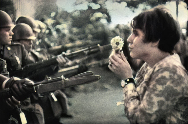 صورة المواجهة المطلقة التى تظهر فيها الناشطة جان روز كاسمير حاملة زهرة مقابل جنود مدججين بالسلاح أمام مبني البنتاجون