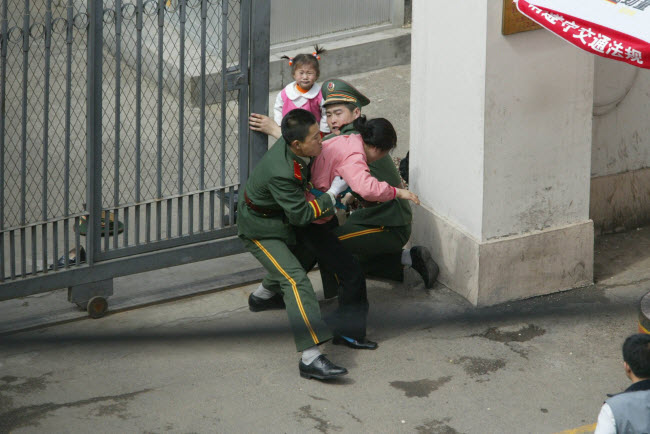 صورة إعتداء الشرطة الصينية على مواطنة كورية شمالية أمام مبني القنصلية اليابانية