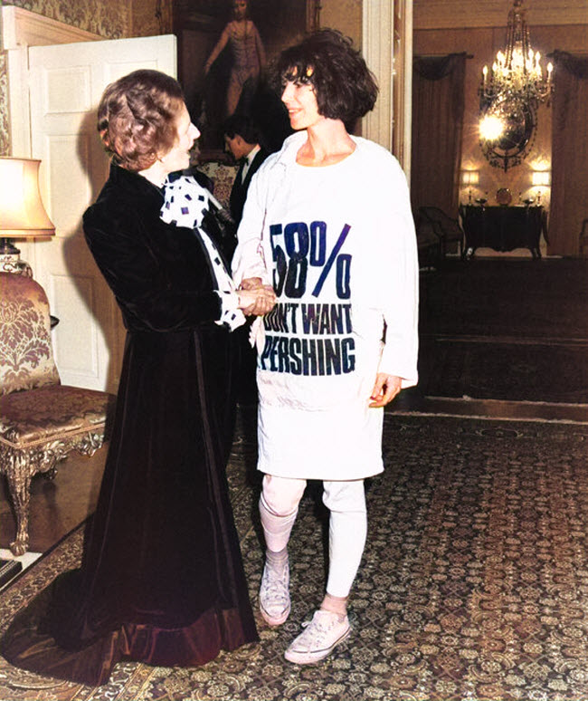 صورة الناشطة و مصممة الأزياء كاثرين هامنيت أثناء لقائها بمارجريت تاتشر و هي ترتدي قميص مليئ بعبارات إحتجاجية