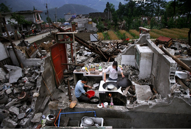 صورة زوجين صينيين يقومون بطهو طعامهم داخل أنقاض منزلهم عقب زلزال سيتشوان المدمر