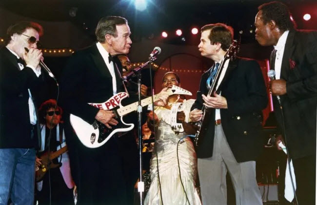 صورة الرئيس الامريكي بوش الأب مع مدير حملته لي أتواتر أثناء عزفهم في حفل غنائي