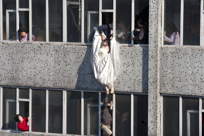 صورة إنقاذ فتاة حاولت إلقاء نفسها من الطابق السابع فى الصين